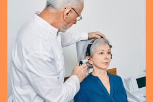 Na zdjęciu lekarz bada słuch seniorce